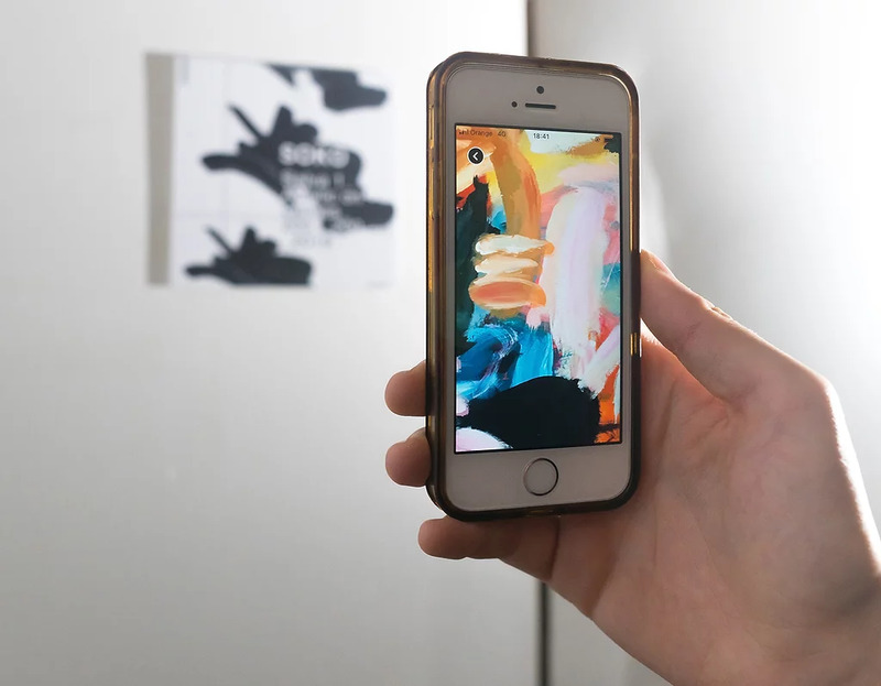 Mobile screen scanning an app artwork marker on the wall