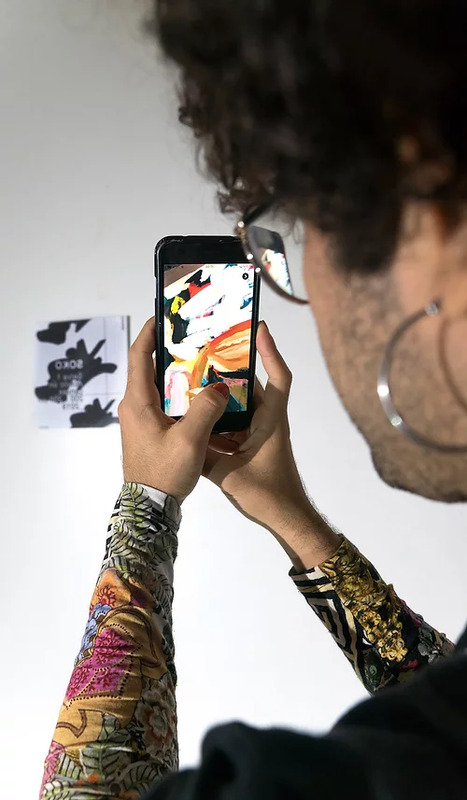 Exhibition visitor scans an app marker on the gallery wall
