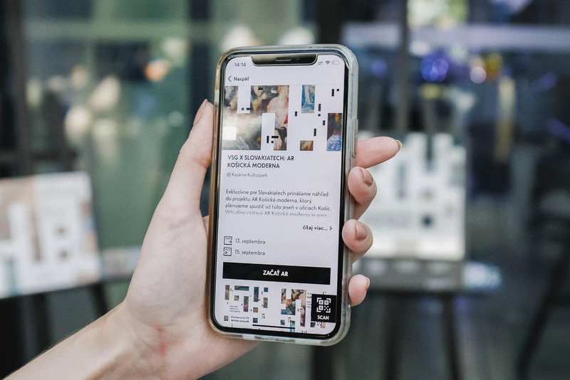 Visitor holding a phone showing artwork information in the app