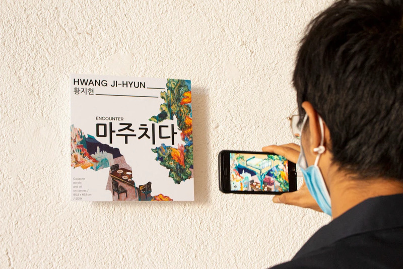 Exhibition visitor scans an app marker on the gallery wall